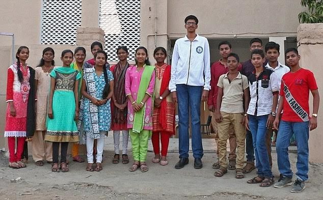 MAHARASHTRA, INDIA – MARCH 25, 2016: India's tallest teenager Yashwant Raut, 14, whose height is 6ft 7in poses for a picture with his classmates at his School in Maharashtra, India. He is now aiming to make world record in boy's category as doctors have told him that he is expected to grow about 8ft tall. Nobody in Yashwant’s family is as tall as him . His mother Suman Raut, 36, is only 4ft 5in tall, while his father Brahmadev Raut, 40, is 5ft 5in tall. Photography by : Cover Asia Press / Vipul Bankatur