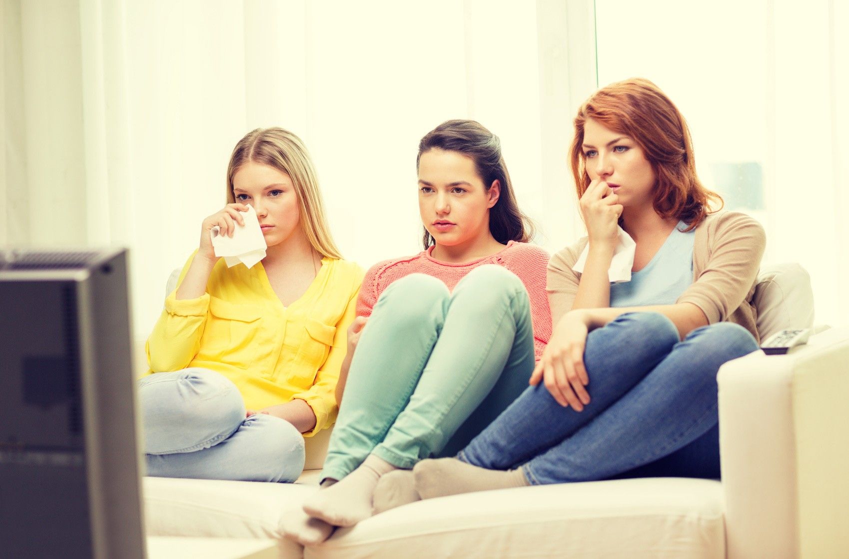 home, technology and friendship concept - three sad teenage girl watching tv at home